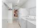 Bright laundry room with tile flooring and a view of a kitchen through a doorway at 7841 Royal Stewart Dr, New Port Richey, FL 34653