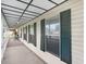 View of an open porch lined with closed shutters and an outside dining set at 7841 Royal Stewart Dr, New Port Richey, FL 34653