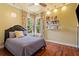 Cozy bedroom with hardwood floors, large windows, and decorative shelving at 8600 Shenandoah Run, Wesley Chapel, FL 33544