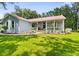 Close-up of the front of the house with a cozy porch, landscaping, and a metal roof at 8600 Shenandoah Run, Wesley Chapel, FL 33544