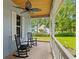 Inviting front porch with brick flooring, ceiling fan and serene views of the lush surroundings at 8600 Shenandoah Run, Wesley Chapel, FL 33544