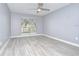 Bright bedroom with modern ceiling fan and view of the neighborhood through a large window at 9481 Highland Oak Dr # 1506, Tampa, FL 33647