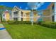 Low angle view of a light yellow condominium building with ample lawn space on a sunny day at 9481 Highland Oak Dr # 1506, Tampa, FL 33647