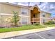 Inviting condo exterior with wood accents and manicured lawn under a bright, cloudy sky at 9481 Highland Oak Dr # 1506, Tampa, FL 33647