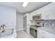 Modern kitchen with stainless steel appliances, white cabinets, and mosaic backsplash at 9481 Highland Oak Dr # 1506, Tampa, FL 33647
