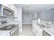 Stylish kitchen featuring stainless steel appliances, white cabinetry, and mosaic backsplash at 9481 Highland Oak Dr # 1506, Tampa, FL 33647