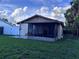 Backyard featuring a screened-in patio, stone walkway, and green lawn at 10102 Missy Ct, Tampa, FL 33615