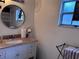 Bathroom vanity features granite countertop, round mirror, and updated fixtures at 10102 Missy Ct, Tampa, FL 33615