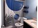 Modern bathroom with blue accents, patterned shower curtain, and decorative towels at 10102 Missy Ct, Tampa, FL 33615