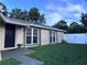 Tan colored home with large windows and a green lawn with a black front door at 10102 Missy Ct, Tampa, FL 33615