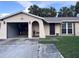 Beige single Gathering home featuring an attached garage, and lawn with mature landscaping at 10102 Missy Ct, Tampa, FL 33615