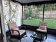 Relaxing screened-in patio with cushioned seating and a view of the green backyard at 10102 Missy Ct, Tampa, FL 33615