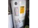 Image shows the GE electric water heater with energy guide and safety labels in the utility area or basement at 10102 Missy Ct, Tampa, FL 33615