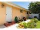 Exterior view of home featuring a backyard, landscaped with green grass, flowers, and stucco wall at 104 Foxwood Dr, Brandon, FL 33510