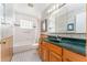 Bathroom with tile floors, white shower and tub, green counters and wood vanity at 104 Foxwood Dr, Brandon, FL 33510