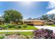 A well-maintained front yard, with colorful flowers, lush greenery, and mature landscaping at the property at 104 Foxwood Dr, Brandon, FL 33510