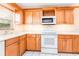 Well-lit kitchen with wood cabinets, white appliances, and plenty of counter space at 104 Foxwood Dr, Brandon, FL 33510