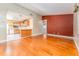 An open-concept living room with wood floors and access to the modern kitchen and stainless steel appliances at 104 Foxwood Dr, Brandon, FL 33510
