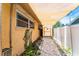 Covered side yard featuring pavers, charming landscaping details, and a tranquil walkway leading to a gate at 104 Foxwood Dr, Brandon, FL 33510