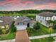 Aerial view of a home with a lake view, features a brick driveway and landscaped front yard at 10842 Rolling Moss Rd, Tampa, FL 33647