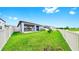 Green backyard enclosed by white fence, patio, and lawn at 10842 Rolling Moss Rd, Tampa, FL 33647