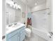 Bright bathroom featuring a blue vanity, a bathtub and shower with colorful shower curtain at 10842 Rolling Moss Rd, Tampa, FL 33647