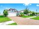Charming two-story home featuring a brick driveway, attached garage, and well-manicured landscaping at 10842 Rolling Moss Rd, Tampa, FL 33647