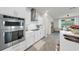 Modern kitchen with stainless steel appliances, white cabinetry, and a kitchen island with sink at 10842 Rolling Moss Rd, Tampa, FL 33647