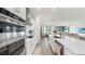 Spacious kitchen featuring stainless appliances, white cabinets, and flowing into a bright living area at 10842 Rolling Moss Rd, Tampa, FL 33647