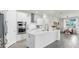 Bright and open kitchen featuring a large island, stainless steel appliances, and white cabinets at 10842 Rolling Moss Rd, Tampa, FL 33647