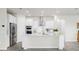 Modern white kitchen with stainless steel appliances, an island with quartz countertops, and plenty of storage at 10842 Rolling Moss Rd, Tampa, FL 33647