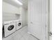 Clean laundry room with modern washer and dryer units and a door to the rest of the home at 10842 Rolling Moss Rd, Tampa, FL 33647