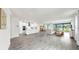 Open concept living area with kitchen, dining area, and living room all connected by wood-look tile at 10842 Rolling Moss Rd, Tampa, FL 33647