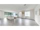Bright, open living room featuring sliding glass doors, wood-look tile, and neutral decor at 10842 Rolling Moss Rd, Tampa, FL 33647