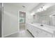 Bright bathroom featuring double sinks, white cabinets, and a separate shower area at 10842 Rolling Moss Rd, Tampa, FL 33647