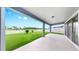 Relaxing covered patio with a view of the manicured lawn and white picket fence at 10842 Rolling Moss Rd, Tampa, FL 33647