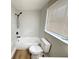 Bright bathroom featuring a white bathtub, shower, and toilet, complemented by modern fixtures and a window at 10914 Oakdale Ave, Port Richey, FL 34668
