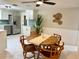Dining area with tile floors, wood table with 4 chairs, kitchen access and overhead lighting at 10914 Oakdale Ave, Port Richey, FL 34668