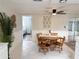 Dining area with tile floors, ceiling fan, tropical decor, view of bedroom, and access to the lanai at 10914 Oakdale Ave, Port Richey, FL 34668