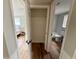 Hallway showcasing hardwood floors, closet, and views into the bedroom and bathroom at 10914 Oakdale Ave, Port Richey, FL 34668