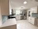 Kitchen with stainless appliances, white cabinets, gray backsplash, updated fixtures, and natural light at 10914 Oakdale Ave, Port Richey, FL 34668