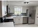 Bright kitchen showcases new stainless steel appliances, including a refrigerator, dishwasher, and range at 10914 Oakdale Ave, Port Richey, FL 34668