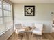 Bright living room featuring wood floors, large window, two chairs, and an open view to the dining area at 10914 Oakdale Ave, Port Richey, FL 34668