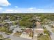 Scenic aerial shot showing a home nestled among lush greenery, with blue skies above a quiet street at 11422 Brown Bear Ln, Port Richey, FL 34668