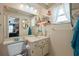 Cozy bathroom featuring a vanity, seashell decor and a window for natural light at 11422 Brown Bear Ln, Port Richey, FL 34668