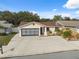 Inviting one-story home with a spacious driveway, a brick-accented garage, and manicured landscaping at 11422 Brown Bear Ln, Port Richey, FL 34668