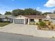 Charming single-story home with a well-maintained lawn, a paved driveway, and an American flag at 11422 Brown Bear Ln, Port Richey, FL 34668