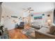 Bright living room with hardwood floors, ceiling fan, and marine-themed decor at 11422 Brown Bear Ln, Port Richey, FL 34668