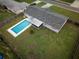 Aerial view of a private backyard featuring a sparkling in-ground pool, screened-in patio, and lush green grass at 123 Jeffrey Dr, Brandon, FL 33511