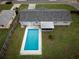 Aerial view of a private backyard featuring a sparkling in-ground pool, screened-in patio, and lush green grass at 123 Jeffrey Dr, Brandon, FL 33511